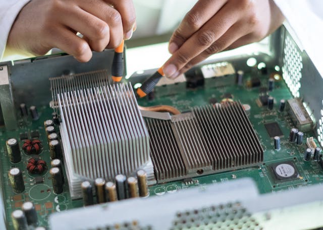 Close-up of the hands of a person who's doing an electric engineering project. Image by Retha Ferguson on Pexels.